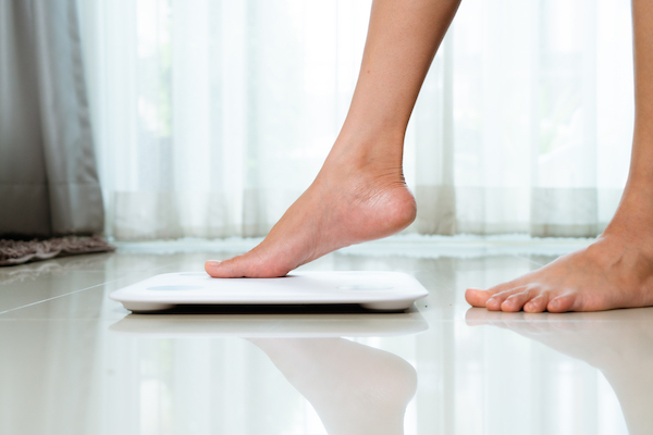 Woman stepping on scale