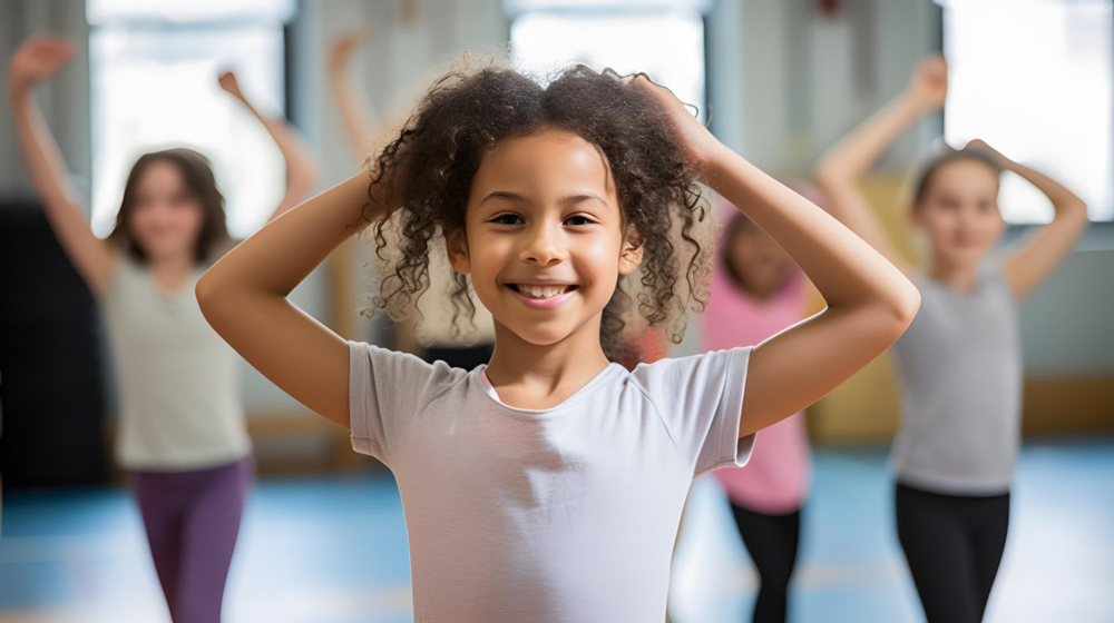A group of young girls participate in a ballet class.