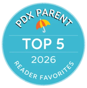 Circular blue badge with an umbrella graphic and the text in white: PDX Parent, Top 5 2026 Reader Favorites